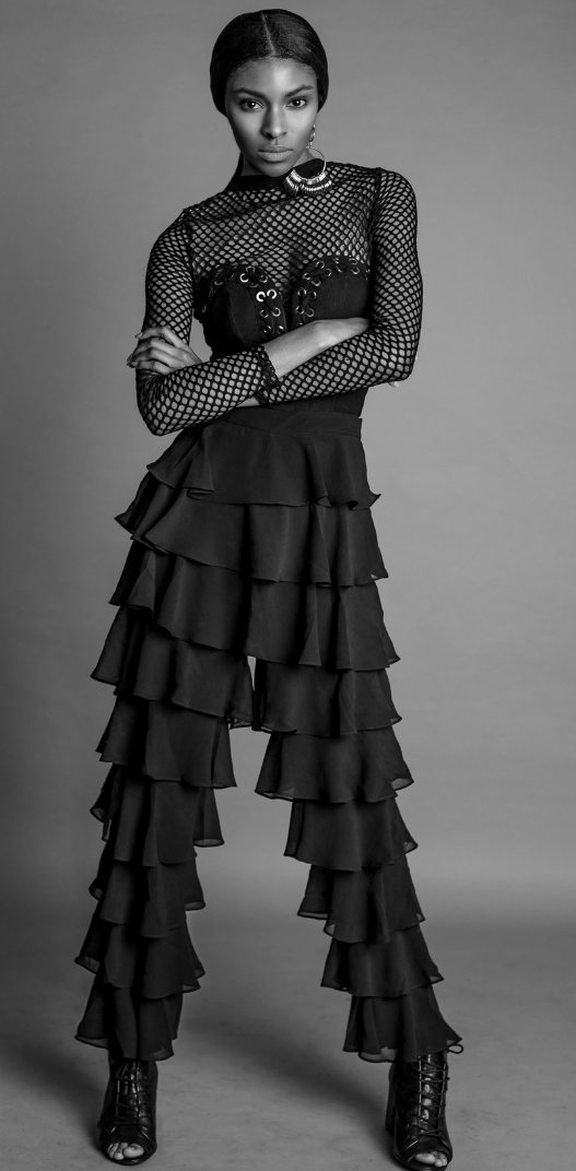 Infinity Jasele, full length, in a black fishnet top and tiered ruffle trousers